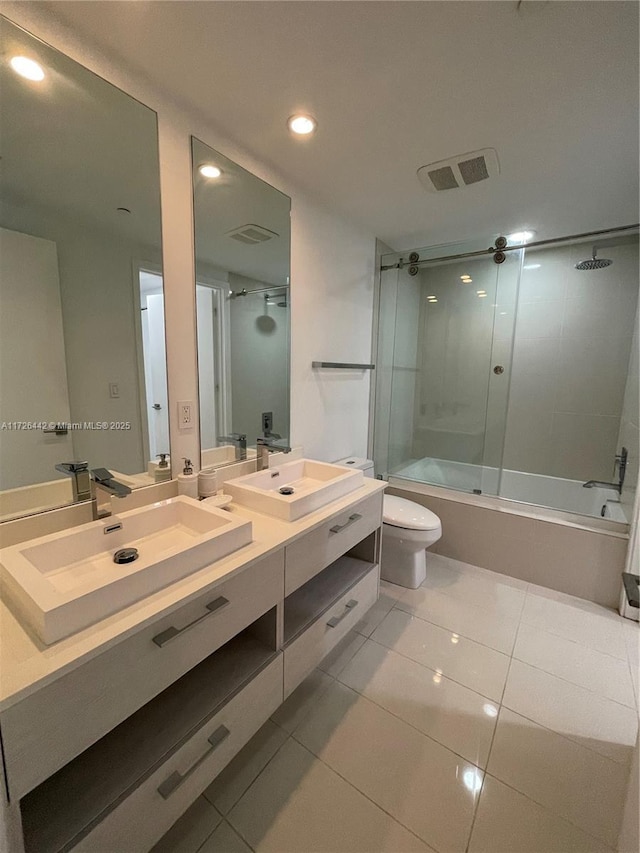 full bathroom featuring toilet, tile patterned flooring, enclosed tub / shower combo, and vanity