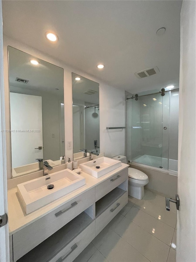 full bathroom with vanity, toilet, bath / shower combo with glass door, and tile patterned flooring