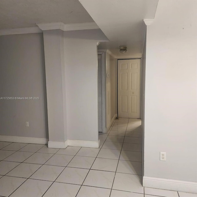 corridor featuring light tile patterned floors and ornamental molding