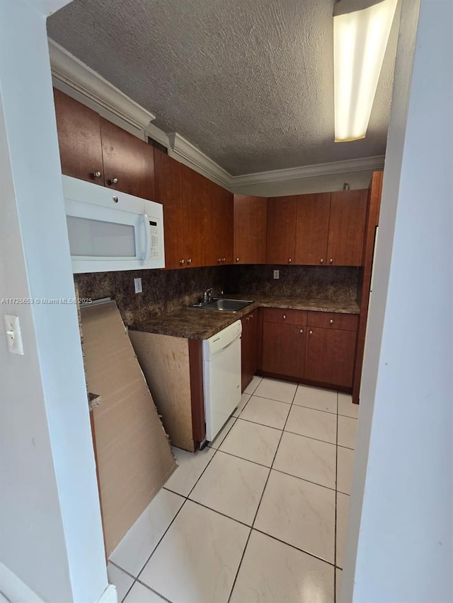 kitchen featuring white appliances, a textured ceiling, sink, light tile patterned floors, and crown molding