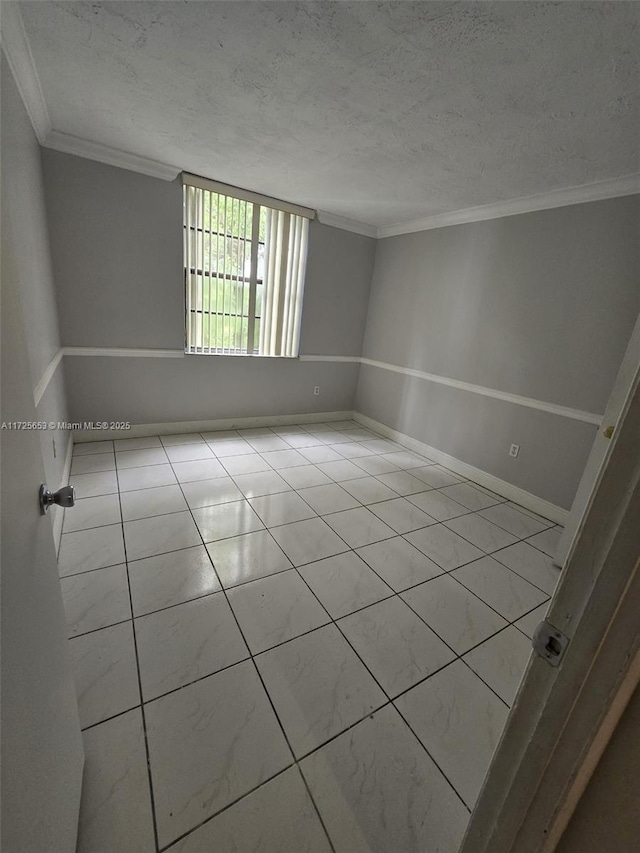 spare room featuring a textured ceiling and ornamental molding