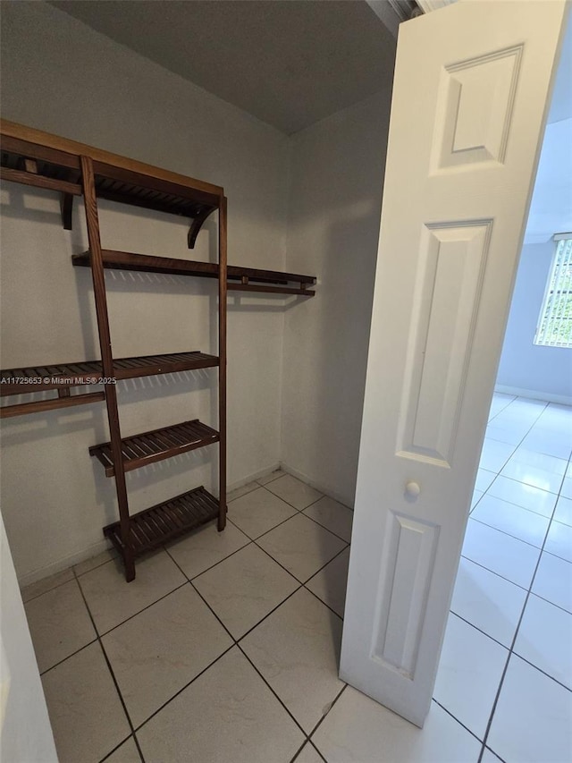 walk in closet with light tile patterned floors