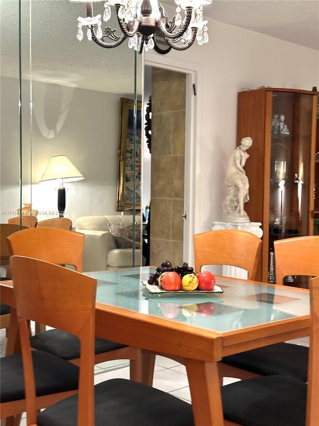 tiled dining room featuring a textured ceiling and a notable chandelier