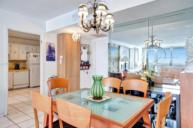 dining space with light tile patterned flooring, a chandelier, and a textured ceiling