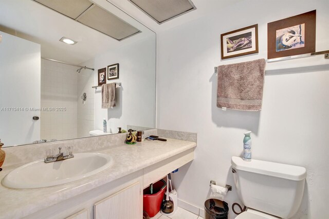 bathroom featuring tiled shower, vanity, and toilet