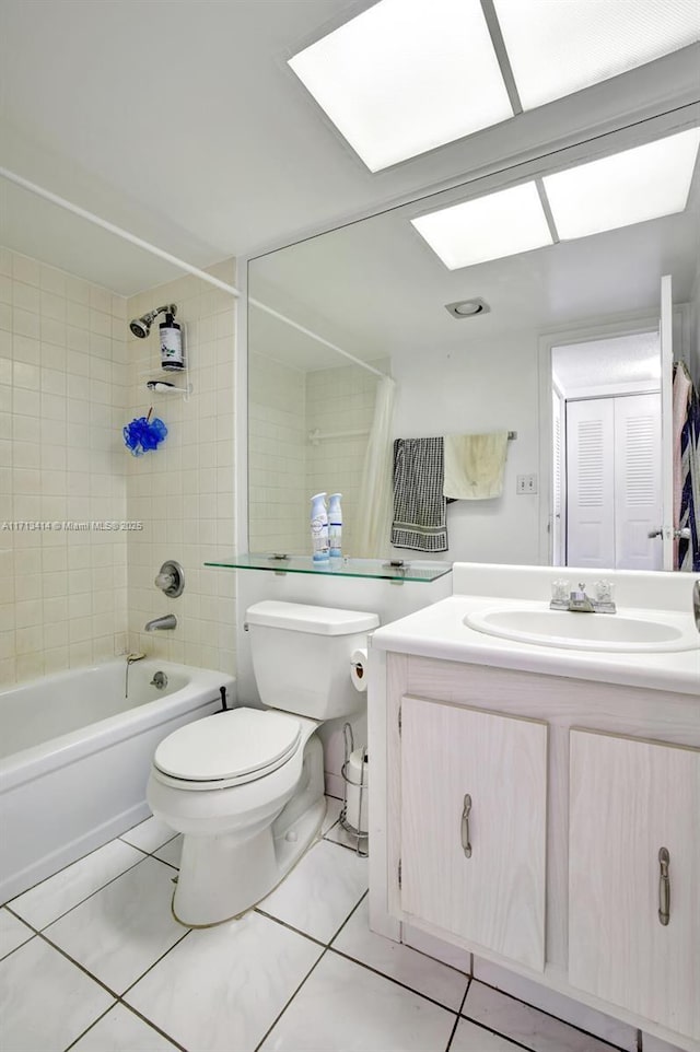 full bathroom with vanity, tiled shower / bath, tile patterned floors, and toilet