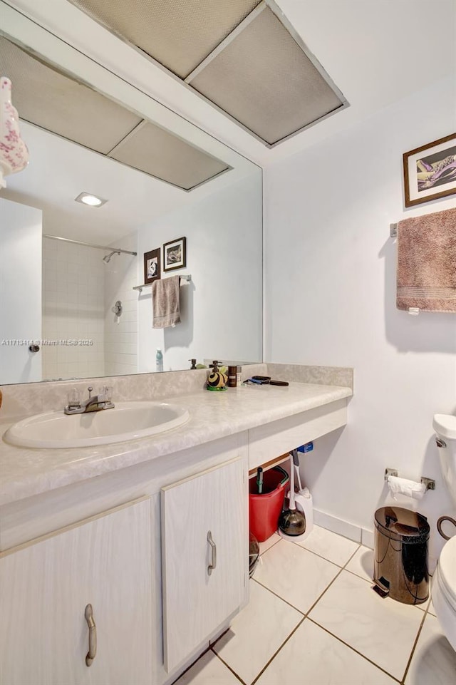 bathroom with tiled shower, vanity, toilet, and tile patterned flooring