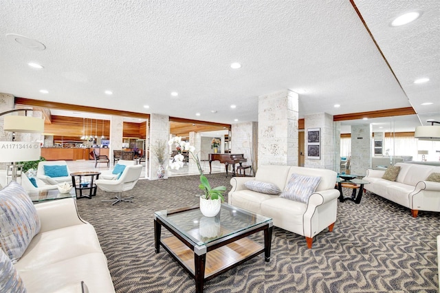 living room with dark carpet, decorative columns, and a textured ceiling