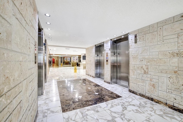 interior space featuring a textured ceiling and elevator