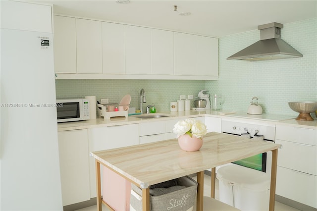 kitchen with sink, white cabinets, wall chimney exhaust hood, backsplash, and stovetop