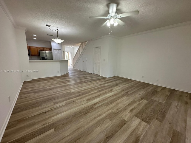 unfurnished living room with ceiling fan, crown molding, and hardwood / wood-style floors