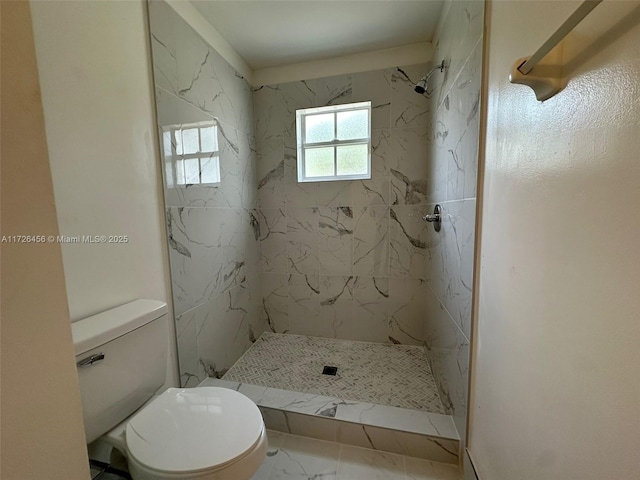 bathroom featuring a tile shower and toilet