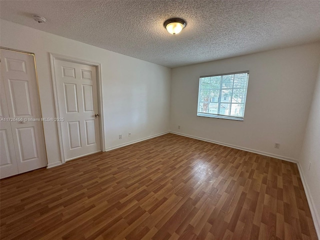 unfurnished room with a textured ceiling and hardwood / wood-style floors