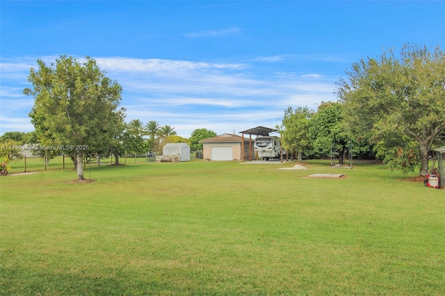 view of yard with a carport, a storage shed, and a garage