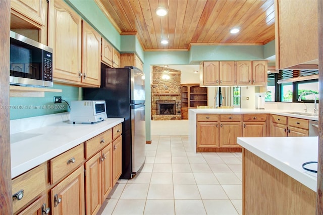 kitchen featuring appliances with stainless steel finishes, a fireplace, sink, wood ceiling, and light brown cabinets