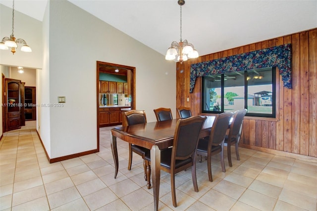 dining space with lofted ceiling, light tile patterned floors, an inviting chandelier, and wood walls