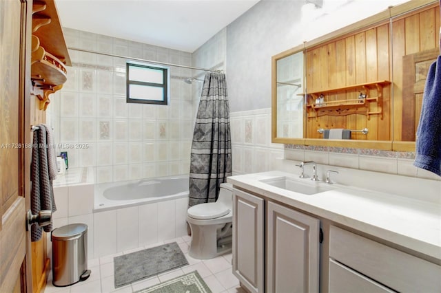 full bathroom with shower / tub combo with curtain, tile patterned floors, toilet, tile walls, and vanity