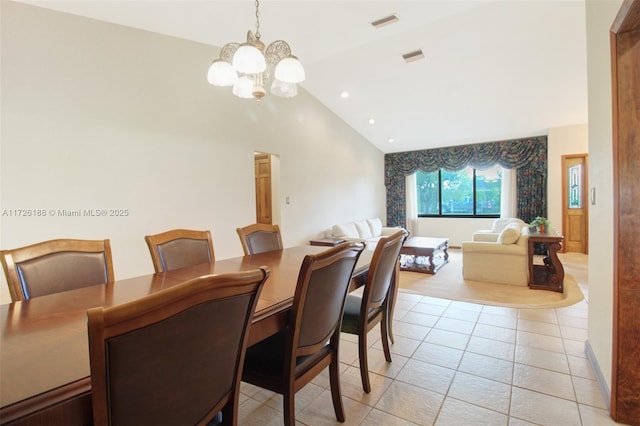 dining area with a notable chandelier, lofted ceiling, and light tile patterned floors