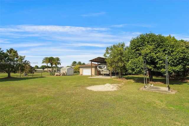 view of yard featuring a garage, a carport, and a storage unit