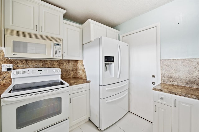 kitchen with white appliances, decorative backsplash, a textured ceiling, and white cabinets