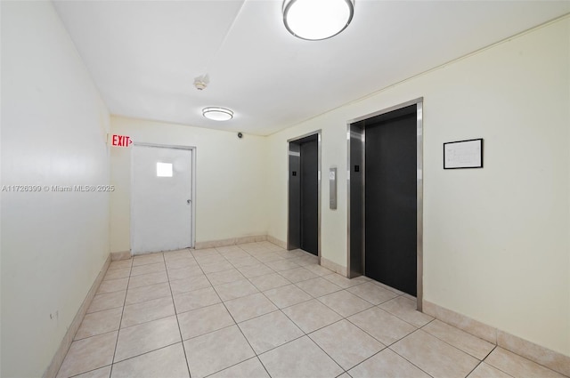 hallway featuring light tile patterned flooring and elevator