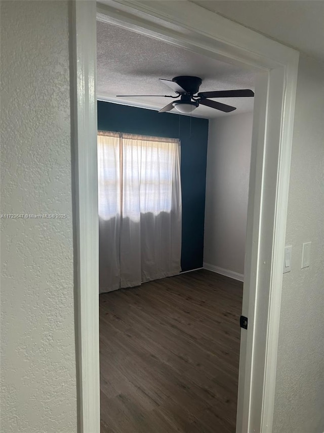 empty room featuring a textured ceiling, ceiling fan, and wood-type flooring