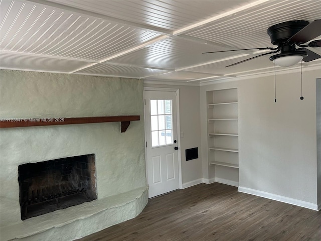 unfurnished living room featuring built in shelves, ceiling fan, dark hardwood / wood-style flooring, and a stone fireplace