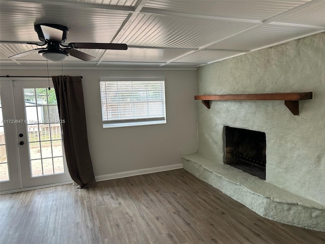 unfurnished living room with ceiling fan, french doors, a stone fireplace, and hardwood / wood-style flooring