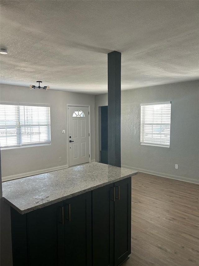 kitchen with light wood-type flooring and light stone countertops