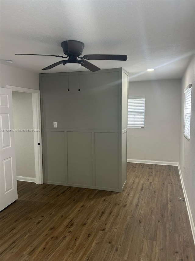 empty room featuring ceiling fan and dark hardwood / wood-style flooring