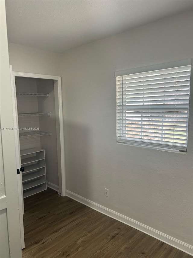 unfurnished bedroom featuring dark hardwood / wood-style flooring and a closet