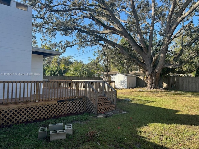 view of yard featuring a storage shed and a wooden deck