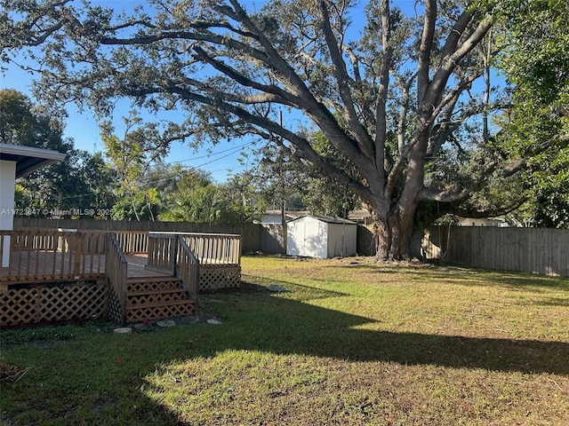 view of yard featuring a storage unit and a wooden deck