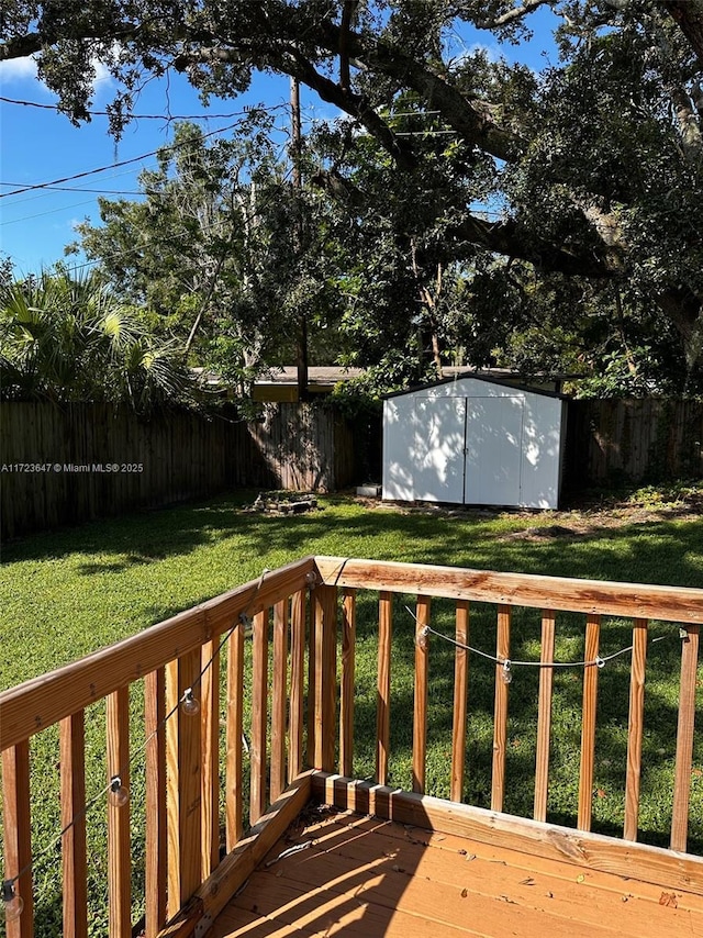 wooden terrace featuring a storage unit and a lawn