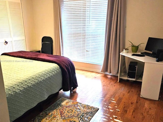 bedroom with wood-type flooring and a closet