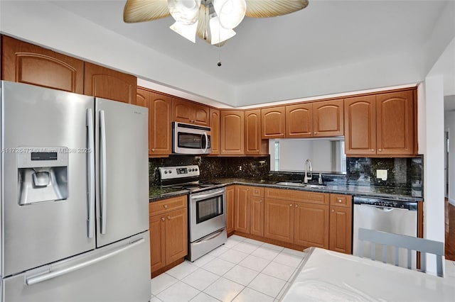 kitchen with appliances with stainless steel finishes, ceiling fan, light tile patterned floors, and sink