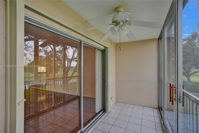 unfurnished sunroom featuring ceiling fan and a wealth of natural light