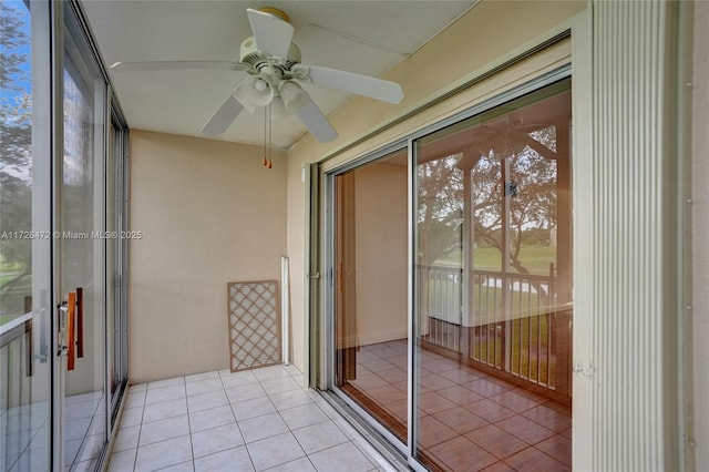 unfurnished sunroom with ceiling fan