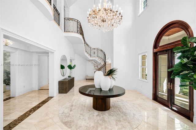 entryway with a high ceiling, french doors, and a healthy amount of sunlight