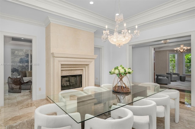 dining space with a fireplace, ornamental molding, and an inviting chandelier