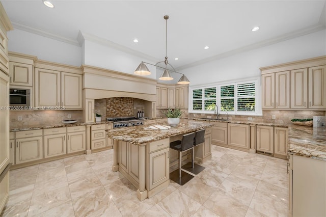 kitchen featuring cream cabinetry, backsplash, a kitchen island, and pendant lighting