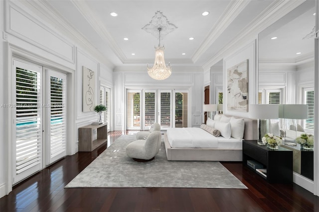 bedroom featuring access to exterior, a notable chandelier, crown molding, a tray ceiling, and dark wood-type flooring