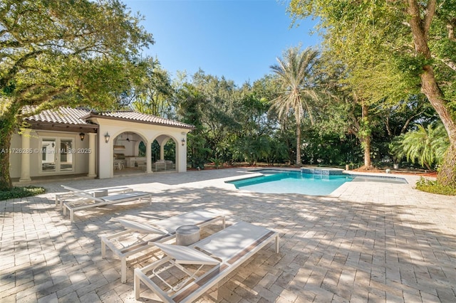 view of pool with a patio area, an outbuilding, and french doors