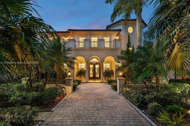 mediterranean / spanish-style home with a balcony and french doors