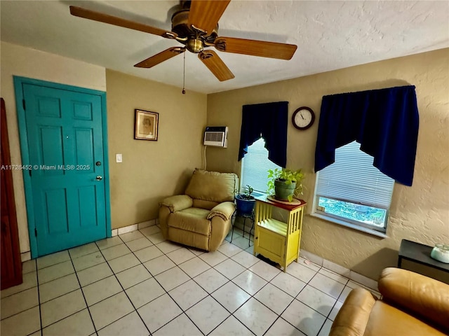 living room with a textured ceiling, ceiling fan, an AC wall unit, and light tile patterned floors