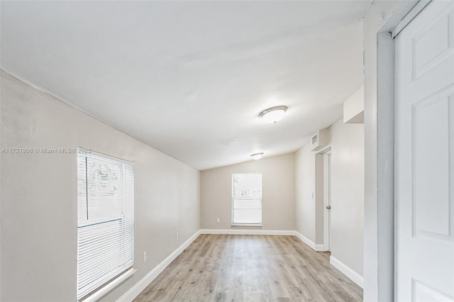 empty room with lofted ceiling and light wood-type flooring