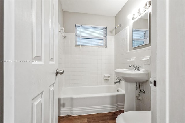 bathroom featuring tiled shower / bath, toilet, and wood-type flooring