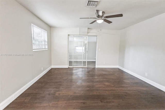 empty room with ceiling fan and dark hardwood / wood-style flooring