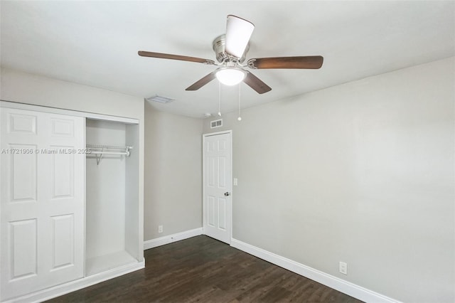 unfurnished bedroom with ceiling fan, a closet, and dark hardwood / wood-style floors