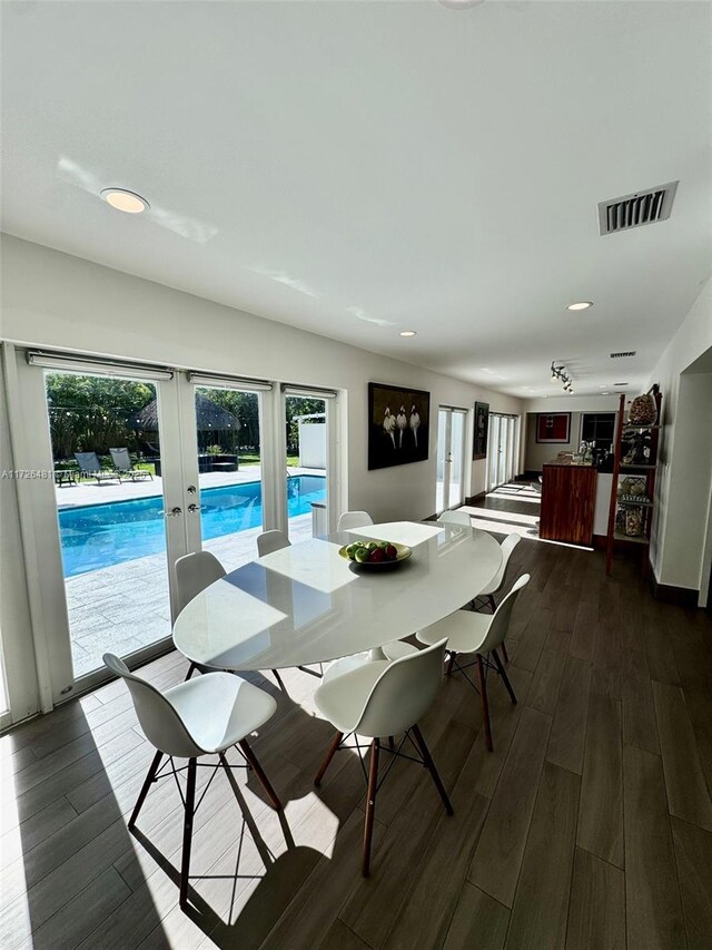 dining space with dark hardwood / wood-style flooring and french doors